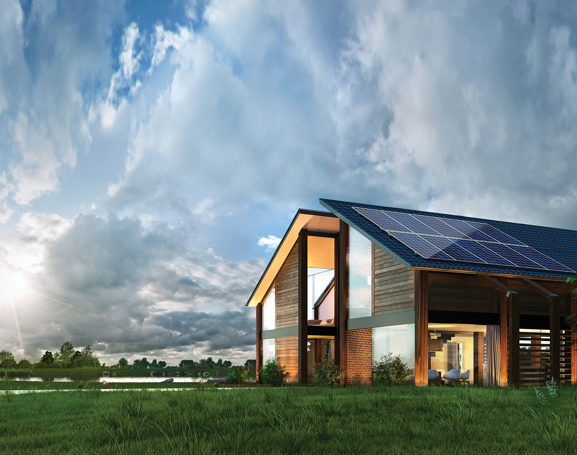 Modern barn-style house with solar panels on sloped roof, large windows, wooden facade, set in grassy field under cloudy sky