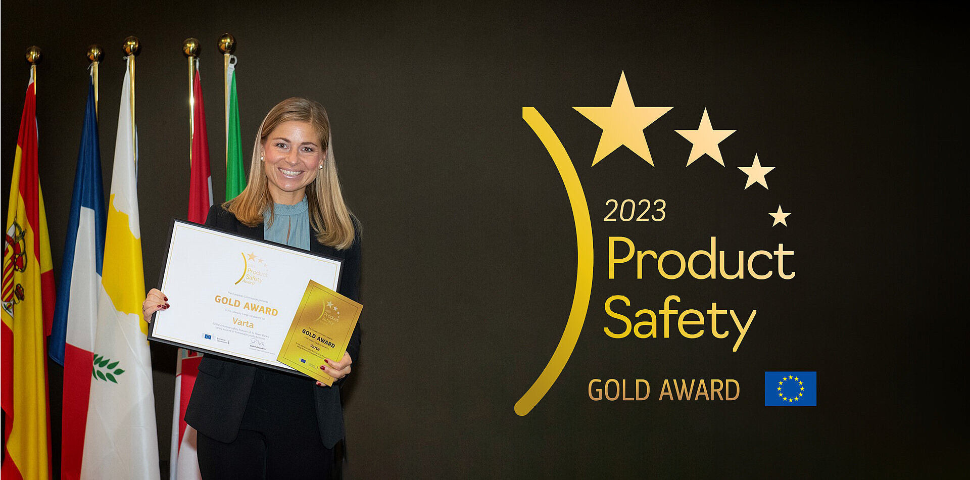 Smiling woman holds Gold Award certificate beside EU flags and 2023 Product Safety Gold Award logo with stars