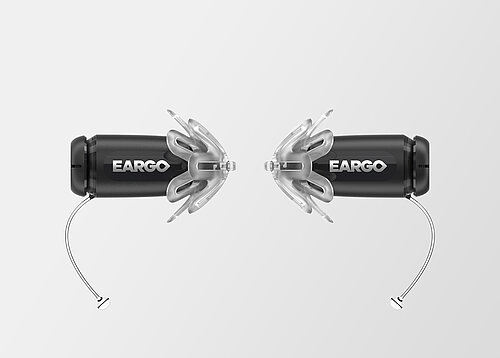Two black Eargo hearing aids with translucent flexible fittings and thin removal wires, facing each other on grey background