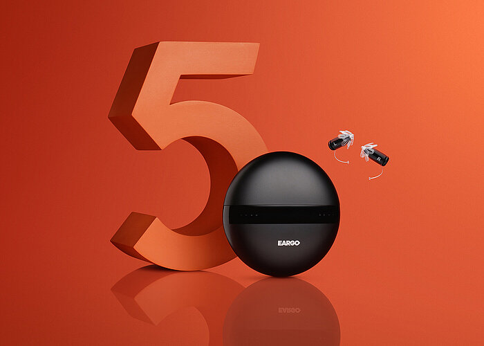 Large 3D orange number 5 beside a round black Eargo charging case and two small hearing aids labeled L and R