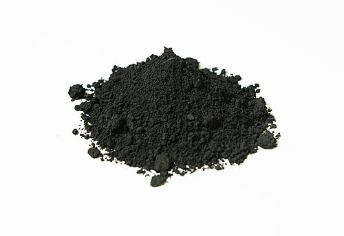 Pile of fine black powder on a white background